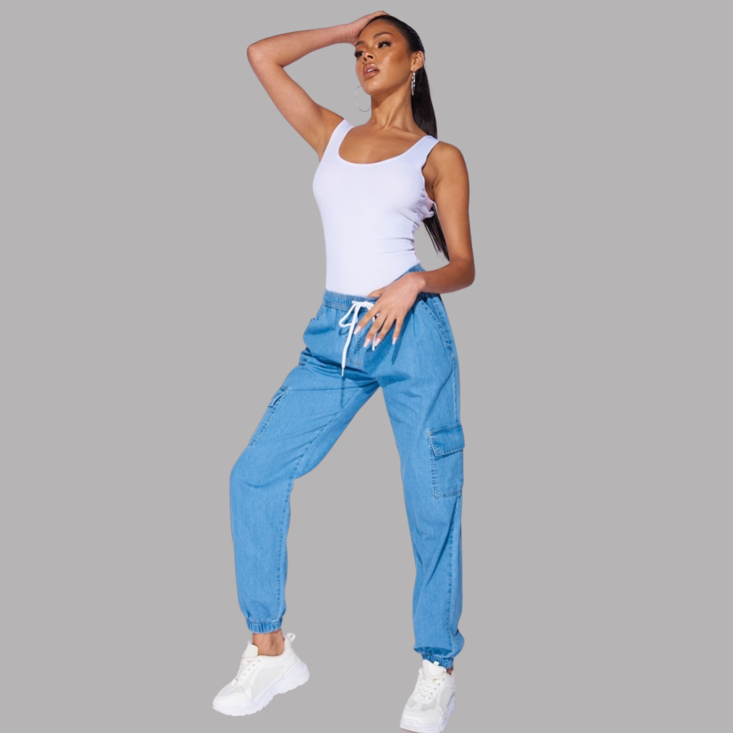 Female model wears light blue denim cargo joggers.