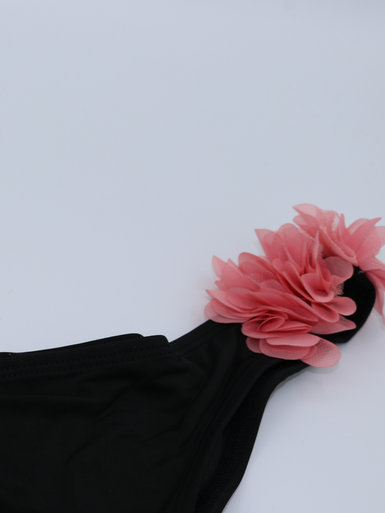 Close up of black bikini brief with chiffon 3d petals at the hip. This statement bikini has an unusual 3d design.