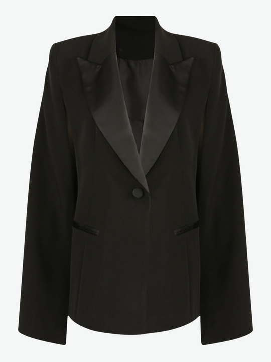 Ghost manequin wears Model wears black cape blazer with side split and black satin lapel. The blazer has front button fastening.  The ghost manequin wears the blazer buttoned.
