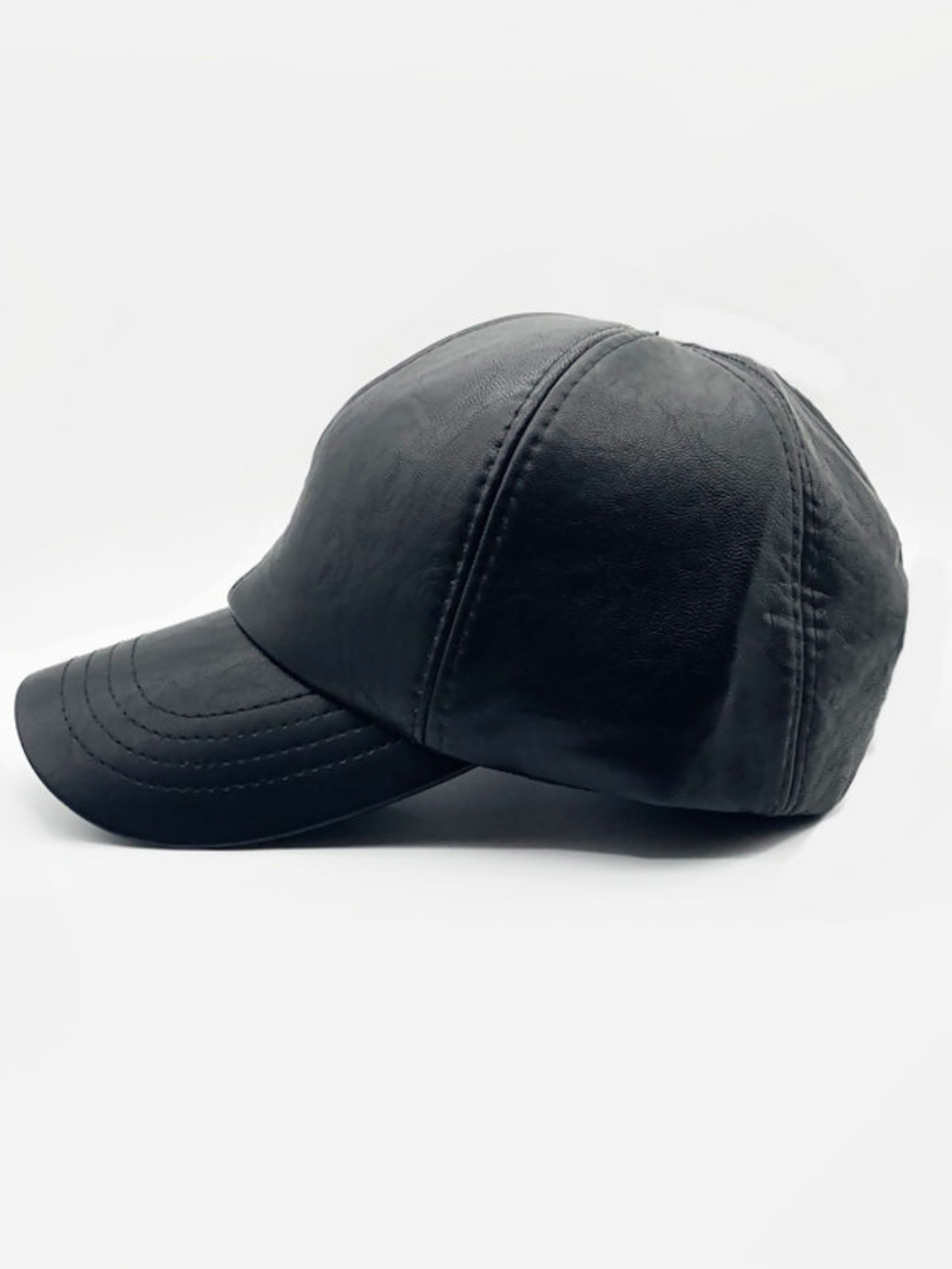 Product shot of the faux leather cap. This leather look faux leather cap has a curved tongue and  black accented stiching.  The picture shows the side of the cap.
