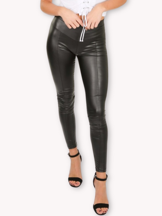 Model wears a wet look, leather looking leggings with panelling. This faux leather leggings has a bodycon slim fit.  The whole of the leggings can be seen, Model wears high heels with the leggings.