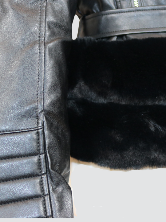 Ghost manequin wears a biker faux leather jacket with faux fur trim. The jacket has leather panelled detailing at the sleeves and exposed asymmetric chunky zip fastening. The faux leather jacket has a removable faux  belted waist.  A close up of the trunk of jacket can be seen, including a belted waist, faux fur trim and pannelled faux fur sleeves.