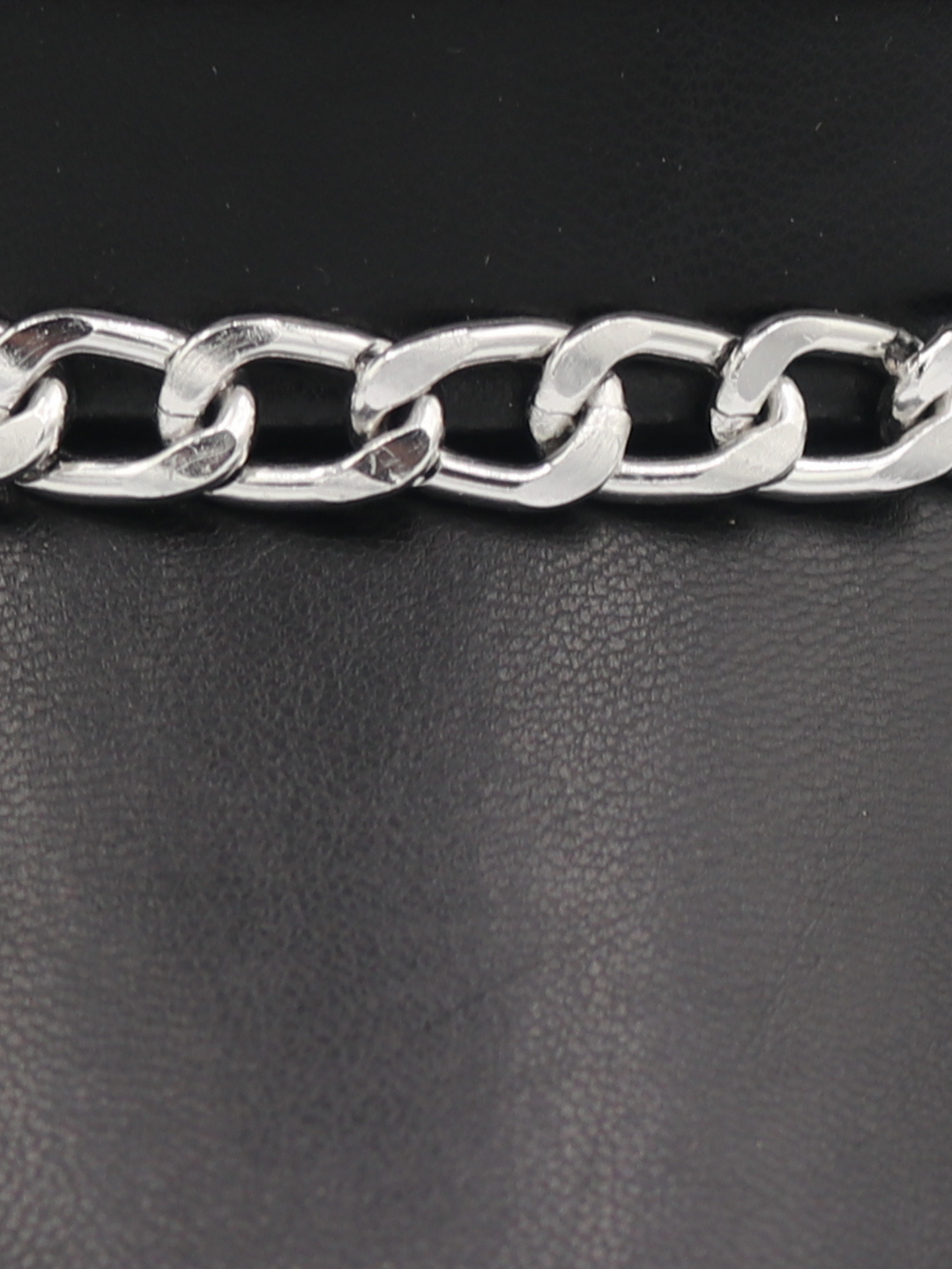 Extreme close up of the PU leather hat, showing the silver linked chain that sits at the front of the PU leather look baker boy hat.
