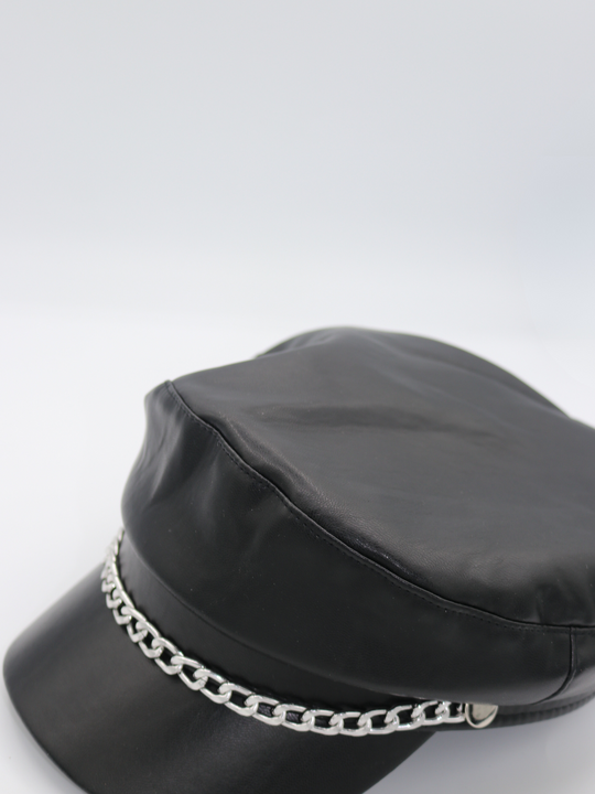 Side profile of the pu leather baker boy hat, demonstrating the front of the cap and the front silver detailing.