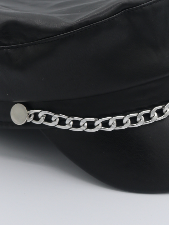 Close up of the pu leather hat. The picture shows a close up of the silver chain detailing at the front of the leather look PU baker boy hat.
