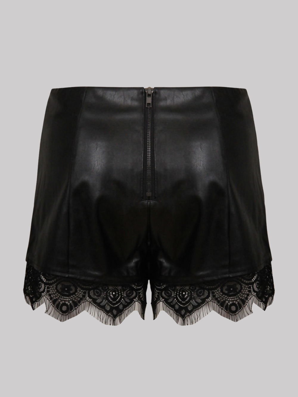 Ghost mannequin wears a  black faux leather shorts with panelled trim, a lace trim at the bottom of the shorts and an exposed zip back fastening. The ghost mannequin stands with her back to the camera, the back of the shorts can be seen, including the exposed zip fastening and the black lace trim at the bottom of the shorts.