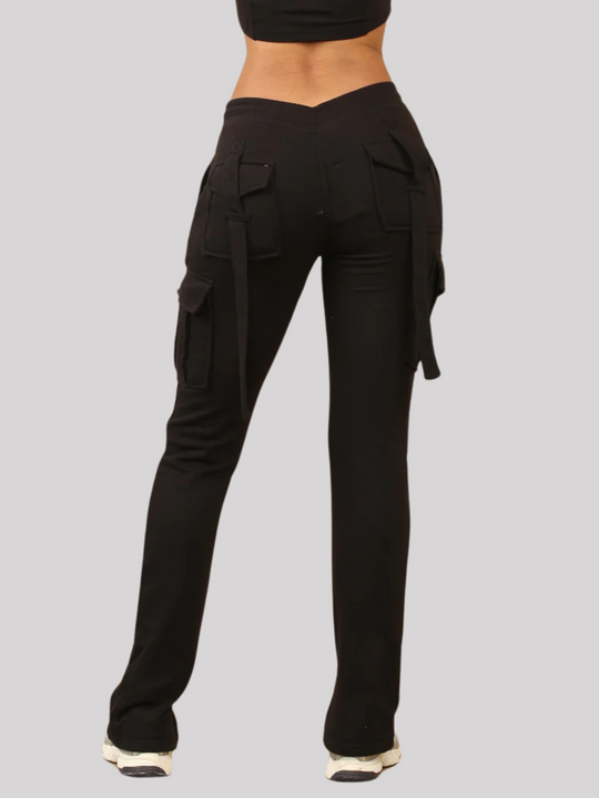 Model wears a Black Cropped Top Hoodie With Zip Front Fastening and Fitted Chargo Jogger Set. The cargo jogger has pockets and one pocket on the long sleeve hoodie. Model has light brown skin, the back of the trousers is in shot, the loop cargo strips can also be seen.