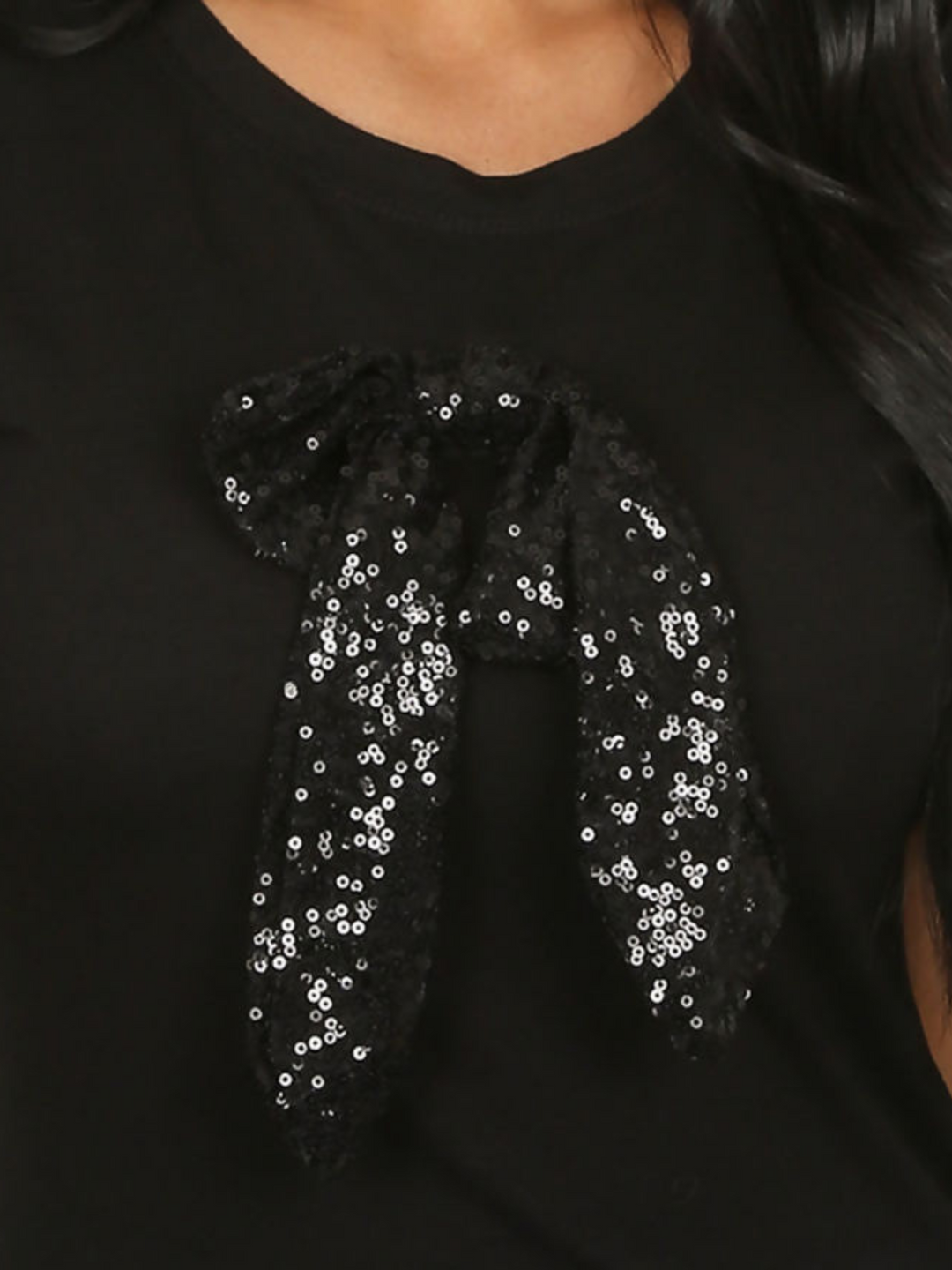 Close up of black sequin bow on the black t shirt.