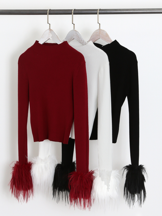 Clothing rail shows 3 long sleeve fine knit jumpers, with a crew neckline and faux fur cuffs. The jumper colours are red, white and black, each jumper shows the faux fur cuffs.