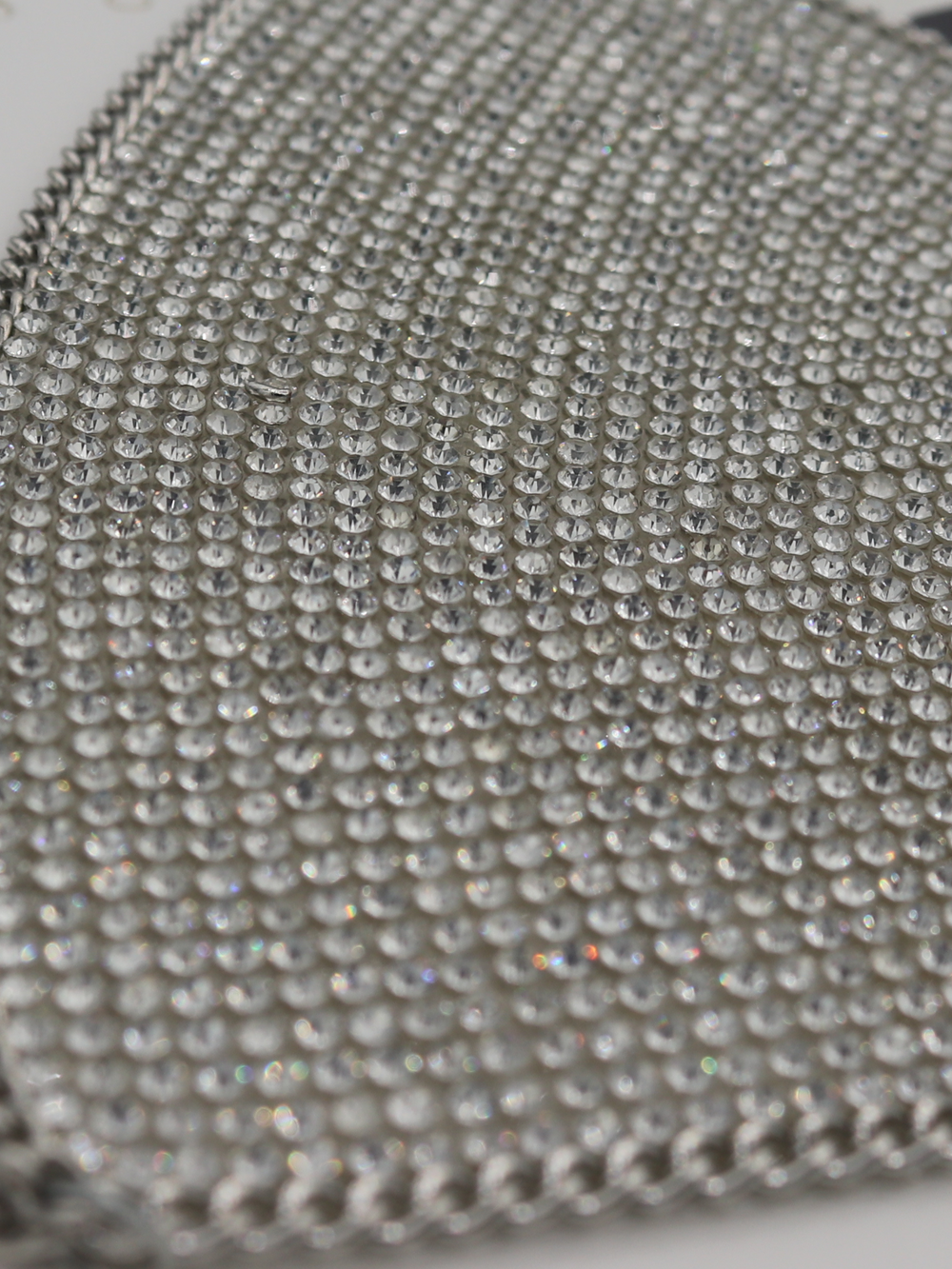 Close up of  silver triangle diamante bralette with chain trim.  The chain detailing and diamante sparkle can be seen.