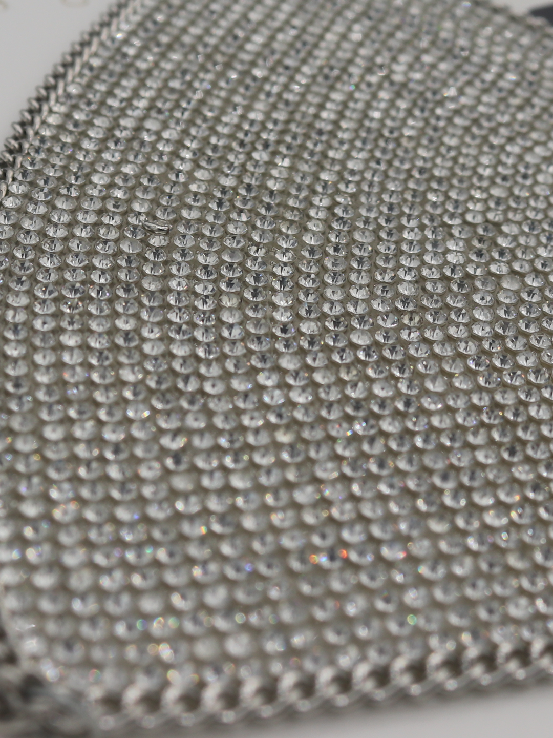 Close up of  silver triangle diamante bralette with chain trim.  The chain detailing and diamante sparkle can be seen.