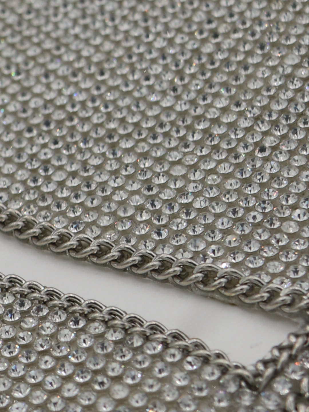Close up of silver triangle diamante bralette with chain trim.  The two parting silver chains can be seen as well as the glistening shimmering diamantes.