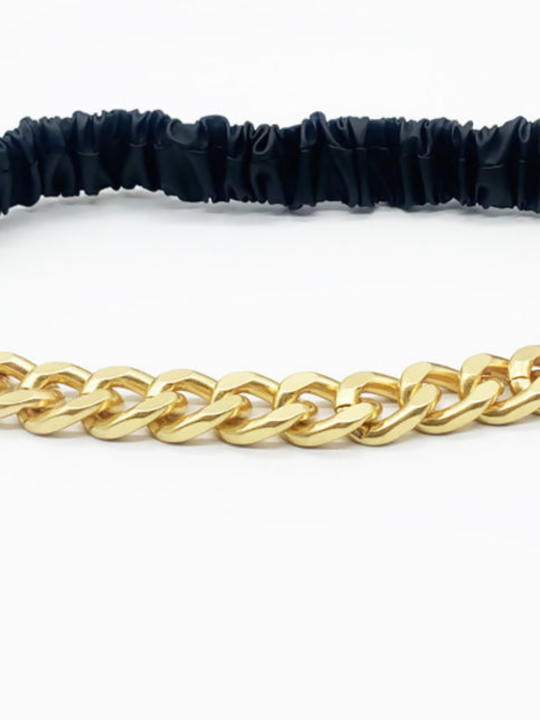 Close up. Gold chain belt with black elasticated adjustable belt, a close up of the gold chain can be seen.
