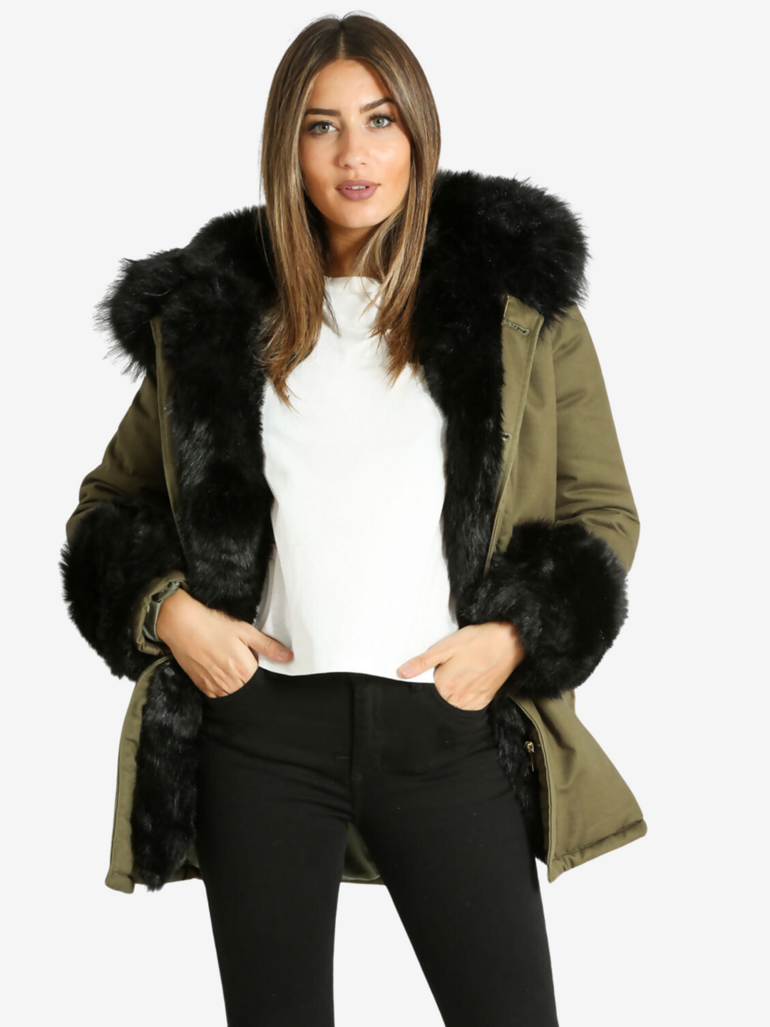 Model wears a green khaki jacket with black faux fur cuffs, a hood with faux fur trim and detachable faux fur frontal flaps. Model faces the camera and wears the jacket open. Model places her hands in her pockets.