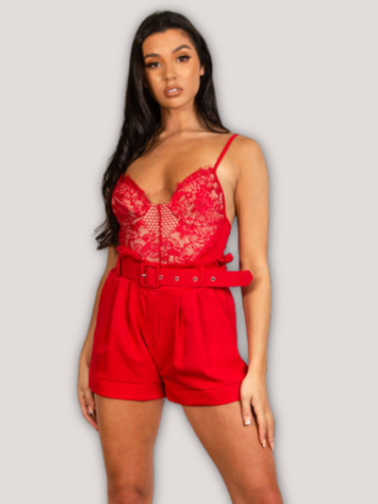 Model wears a red bodysuit with lace panel detailing. Model stands with her hands to the side and one leg outstretched.