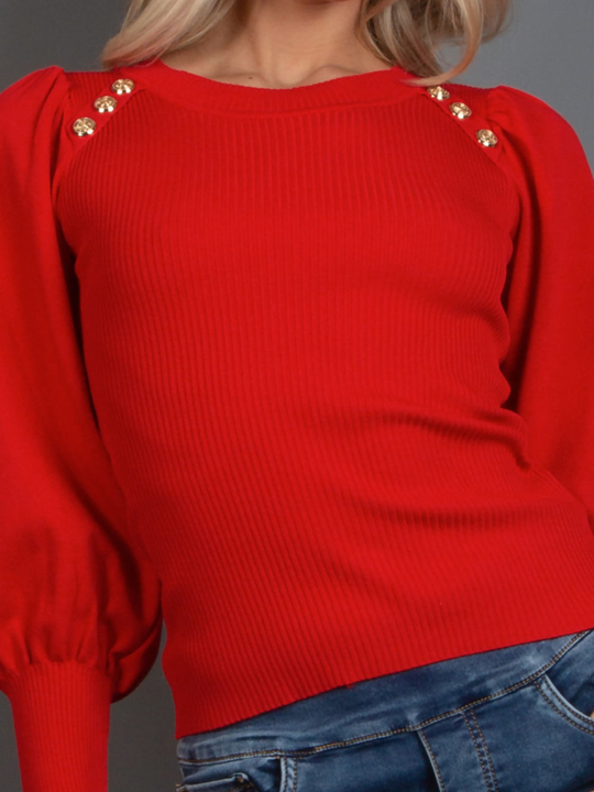 Close up. Female model wears a red long sleeve jumper with a rounded neck and gold military buttons at the front. The photo shows a close up of the ribbed jumper, with gold military buttons at the top of the jumper.