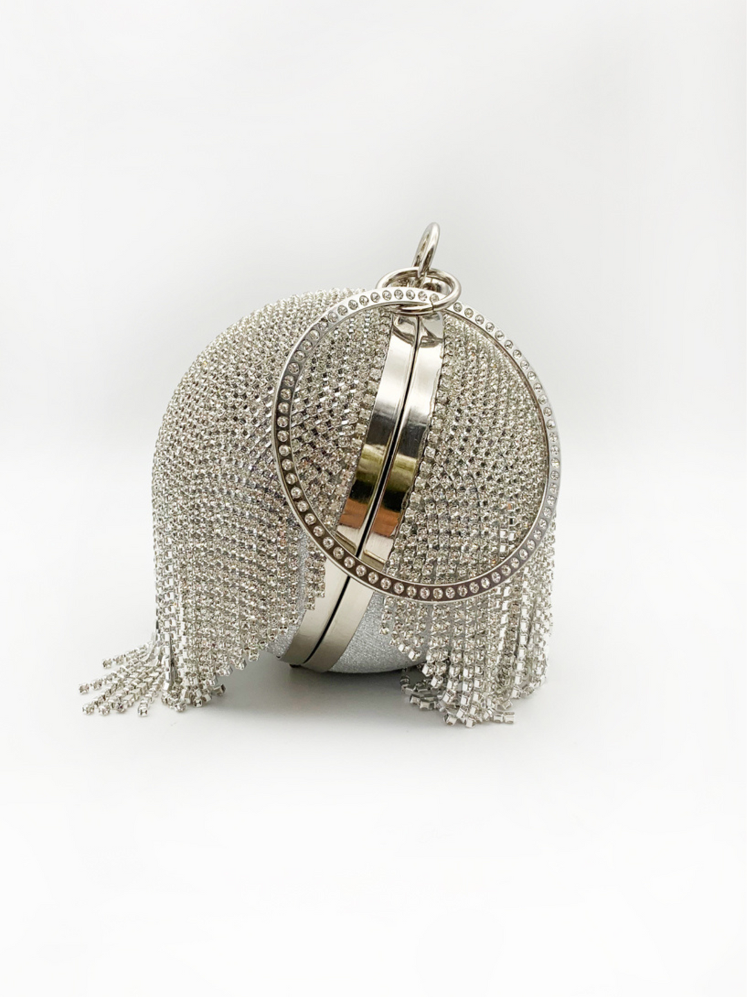 Silver bag, with diamante tassels, clasp fastening and a round diamante handle. The picture shows the bag photographed from the side, demonstrating the sequin diamante tassel, with the rounded handle visible also.