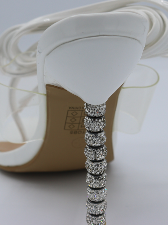White strappy mules shoes with diamante stiletto heel. Extreme closeup of the diamante heels.