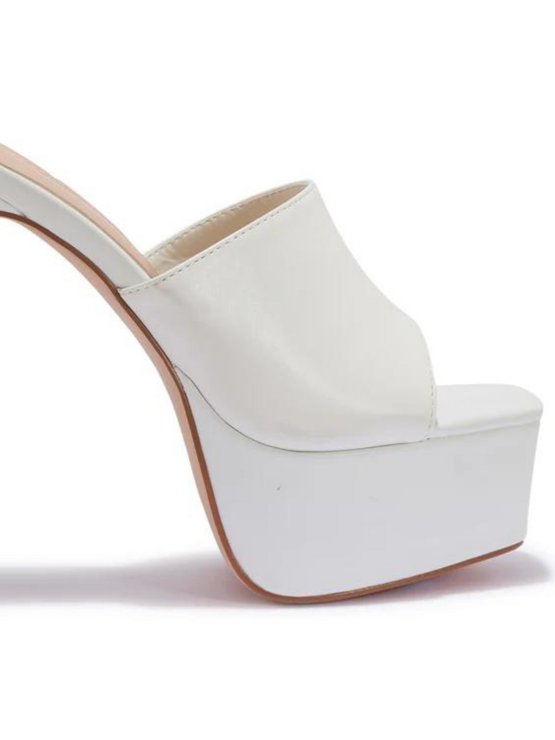 White heeled mules that have a thick platform base and stiletto shoes. The picture shows the thick platform and the shoes band.