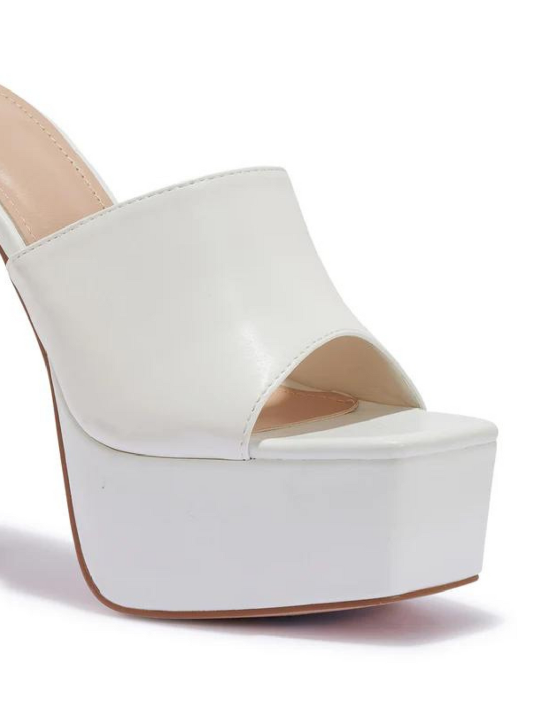 White heeled mules that have a thick platform base and stiletto shoes. The picture shows a close up of the side of the black platform, showing the thick platform base.