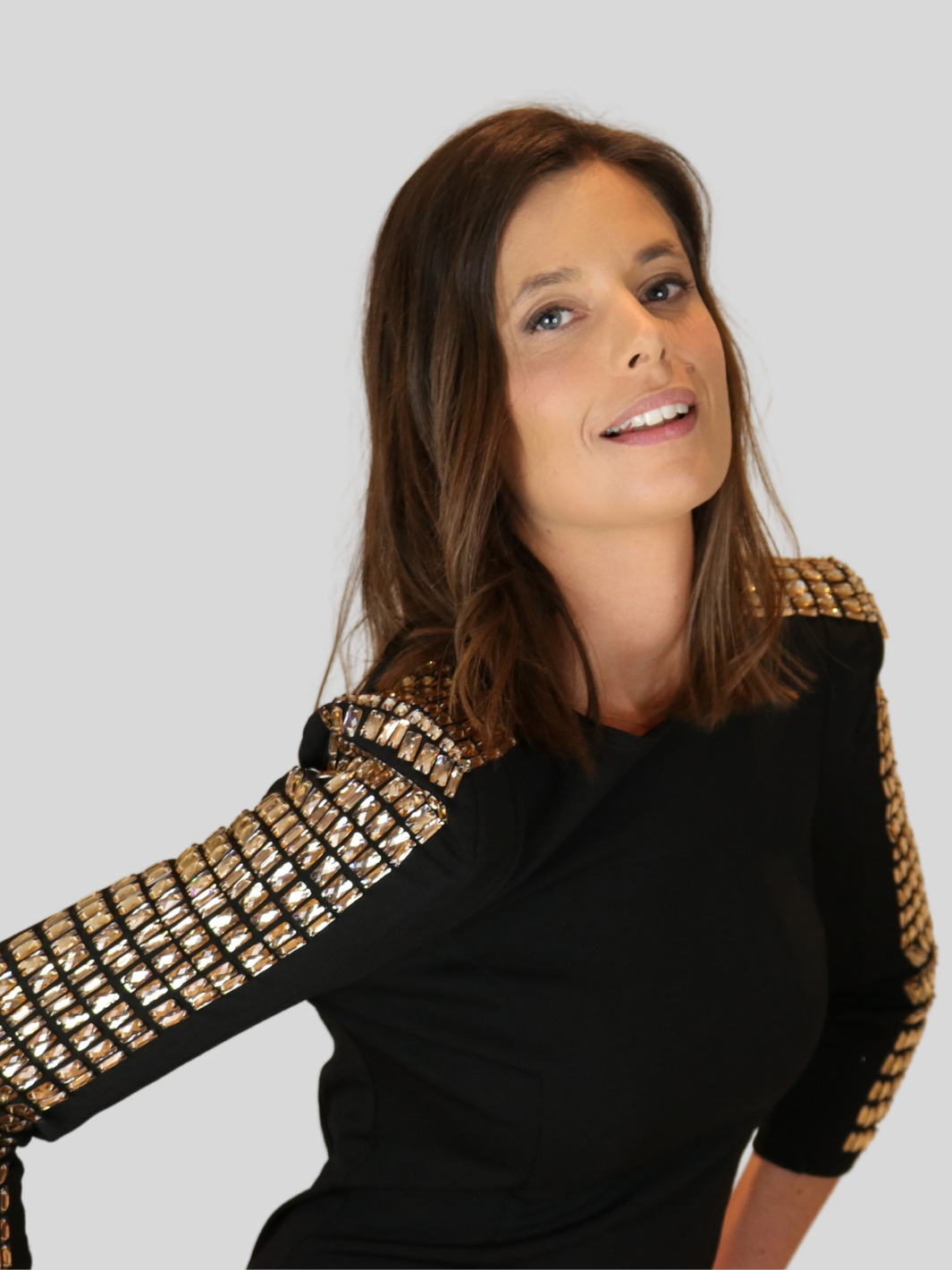 4ever Stunning Deluxe Premium black midi dress with gold rhinestone jeweled arms and chunky gold back zip fastening. Model has both hands on her sides and her head tilted back.