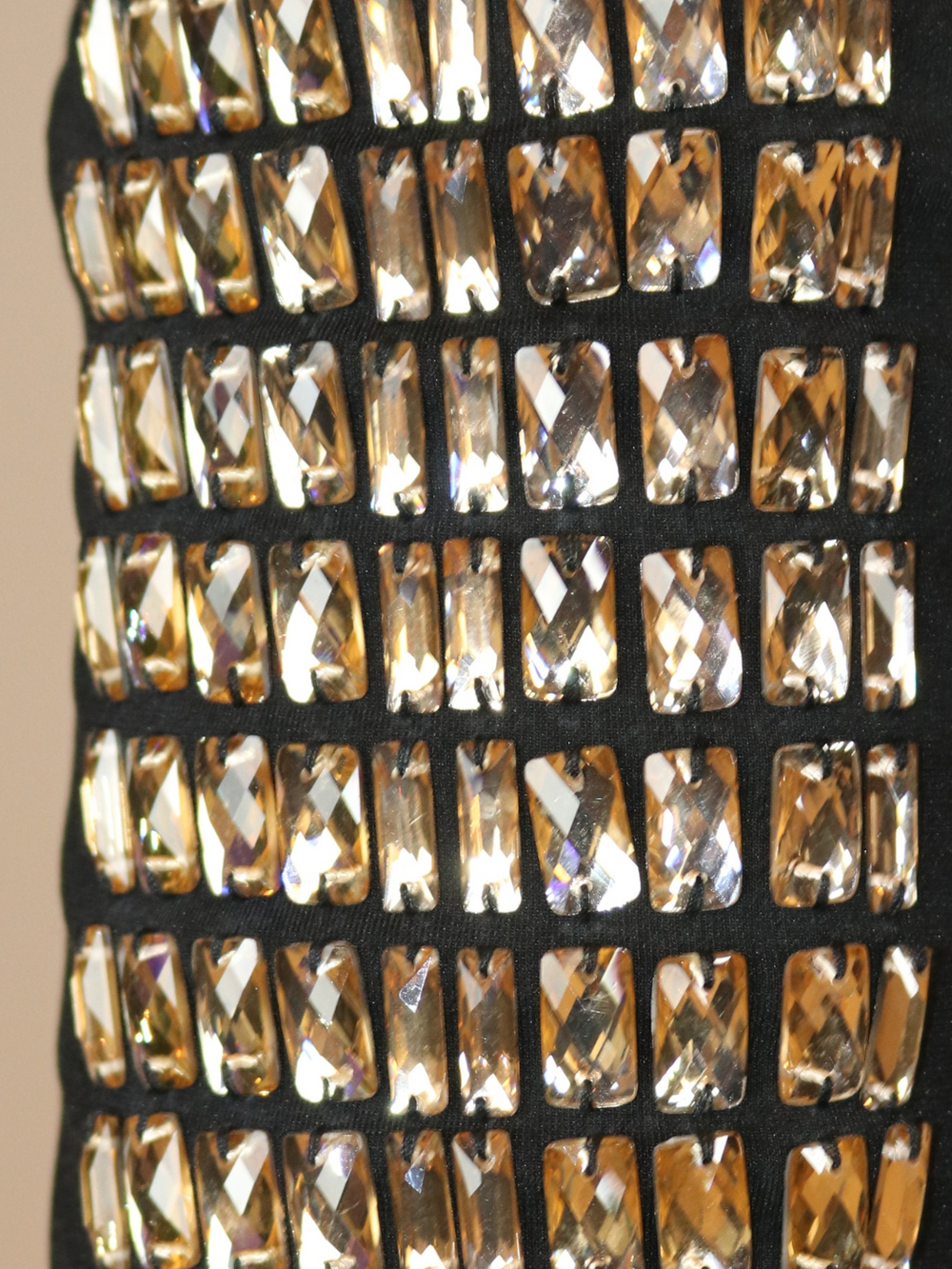 4ever Stunning Deluxe Premium black midi dress with gold rhinestone jeweled arms and chunky gold back zip fastening. Photograph shows a closeup of the rhinestone jeweled sleeves.