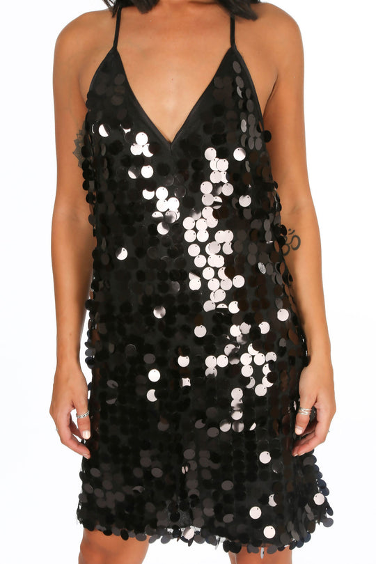 Model wears a shift dress with large sequin circled detailing. The dress has a plunging neckline and spaghetti detailing with an open back. Model stands facing the camera with her hands by her side. There is a close up of the dress with large sequin detailing evident.