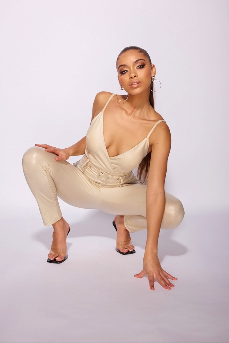 beige_faux_leather_wrapover_front_belted_strappy_jumpsuit_Model_bending_down_