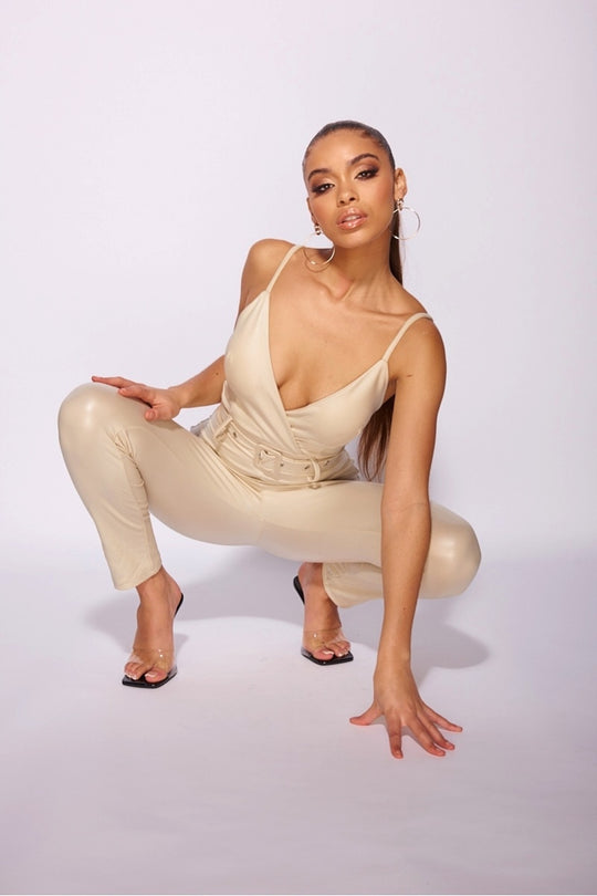 beige_faux_leather_wrapover_front_belted_strappy_jumpsuit_Model_bending_down_