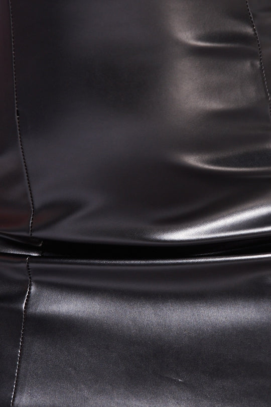 Close up of faux leather bandeau mini dress demonstrating the material.
