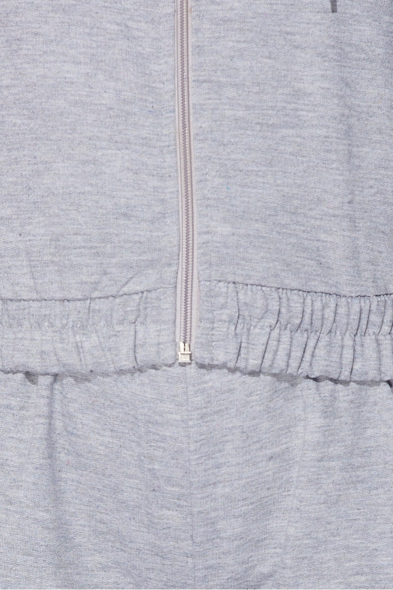 Close up of the material of the  light weight tracksuit with front zip fastening and draws string hood.