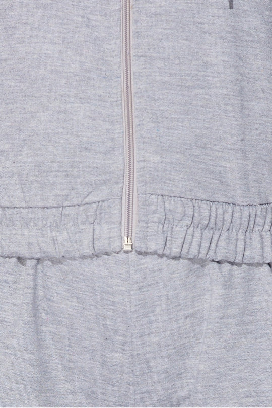 Close up of the material of the  light weight tracksuit with front zip fastening and draws string hood.