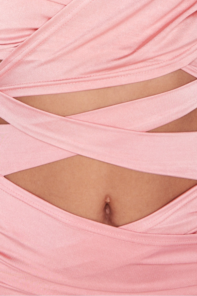 Pink bodycon mini dress with multiway cut out dress with halter neck straps. This is a perfect party dress that is a very sexy dress. Close up of the material with belly button showing.