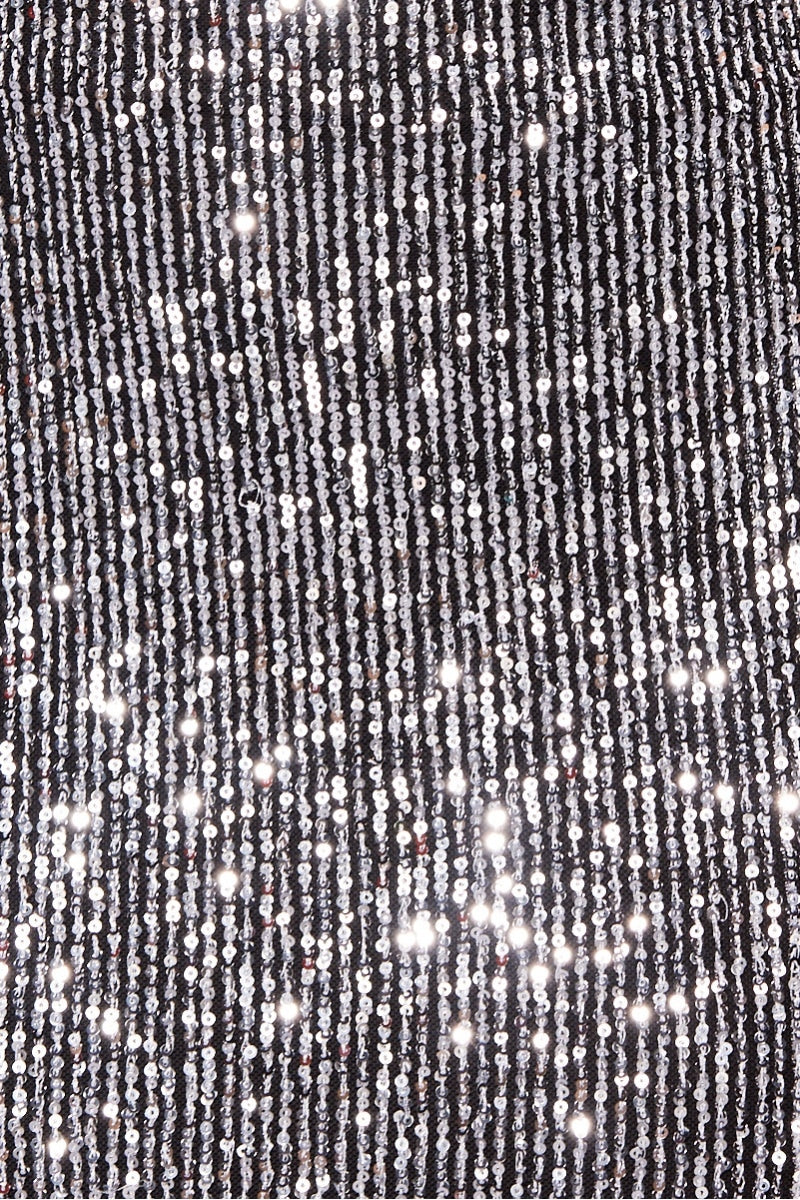 Close up of sequined material. The silver sequin and the black material is visible.