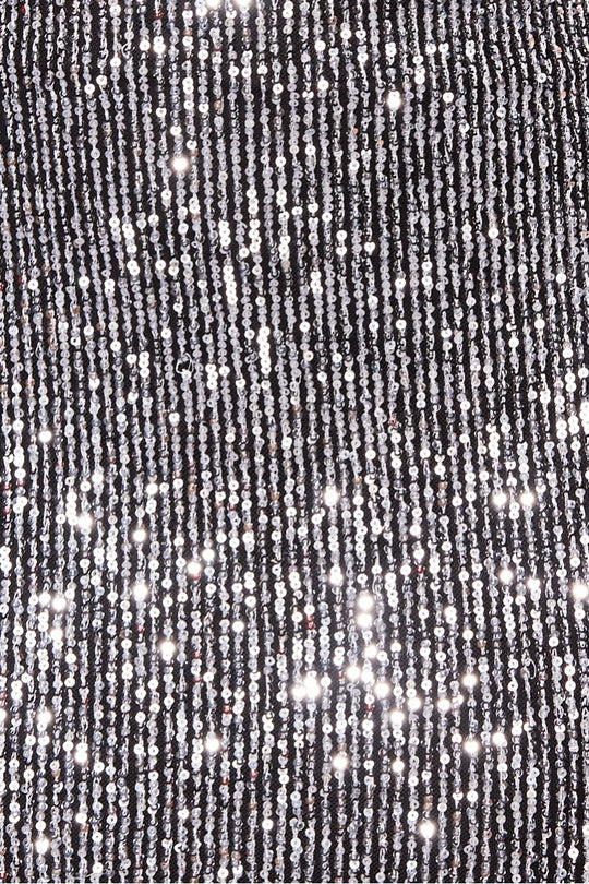 Close up of sequined material. The silver sequin and the black material is visible.
