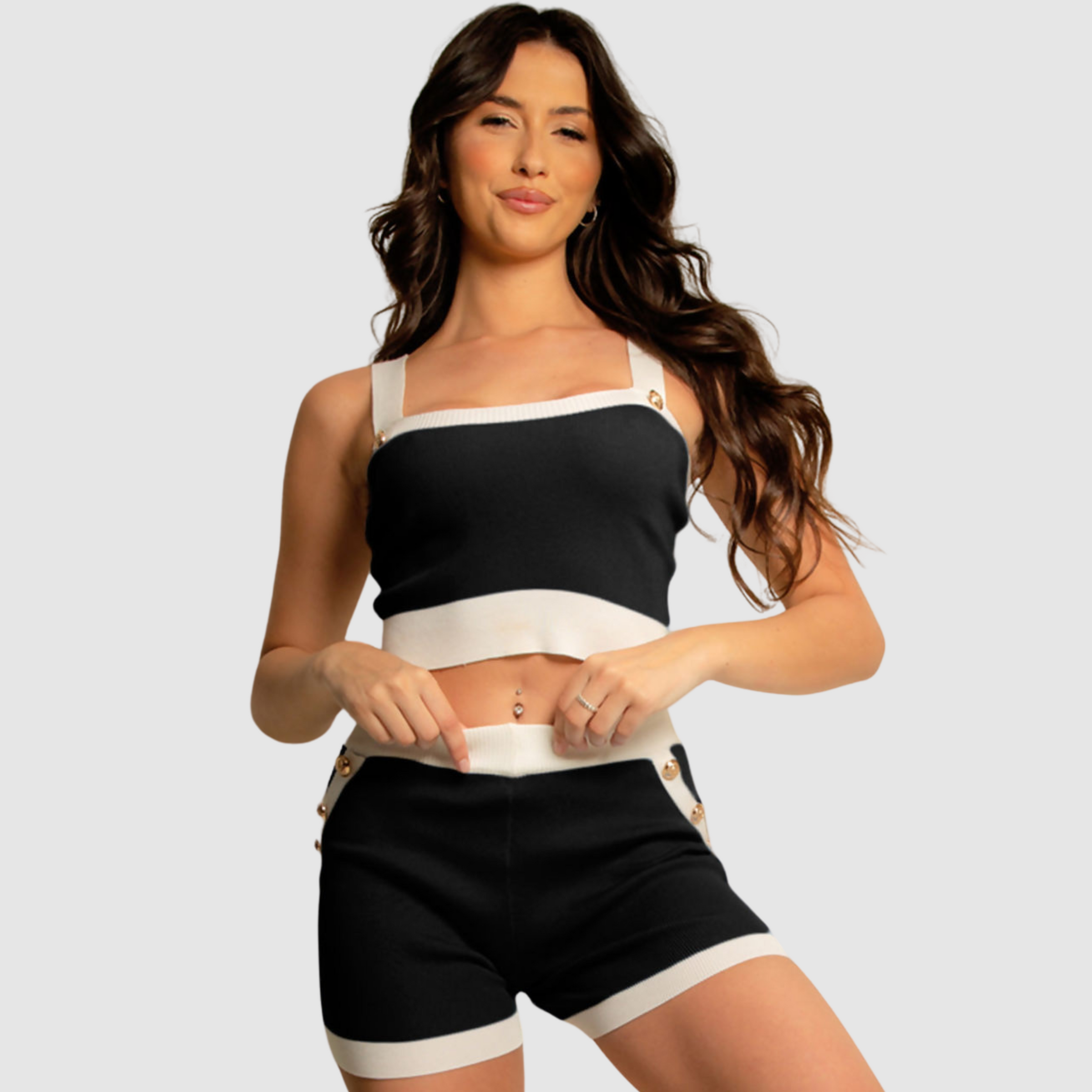woman wears black and white crop top and shorts co ord set.