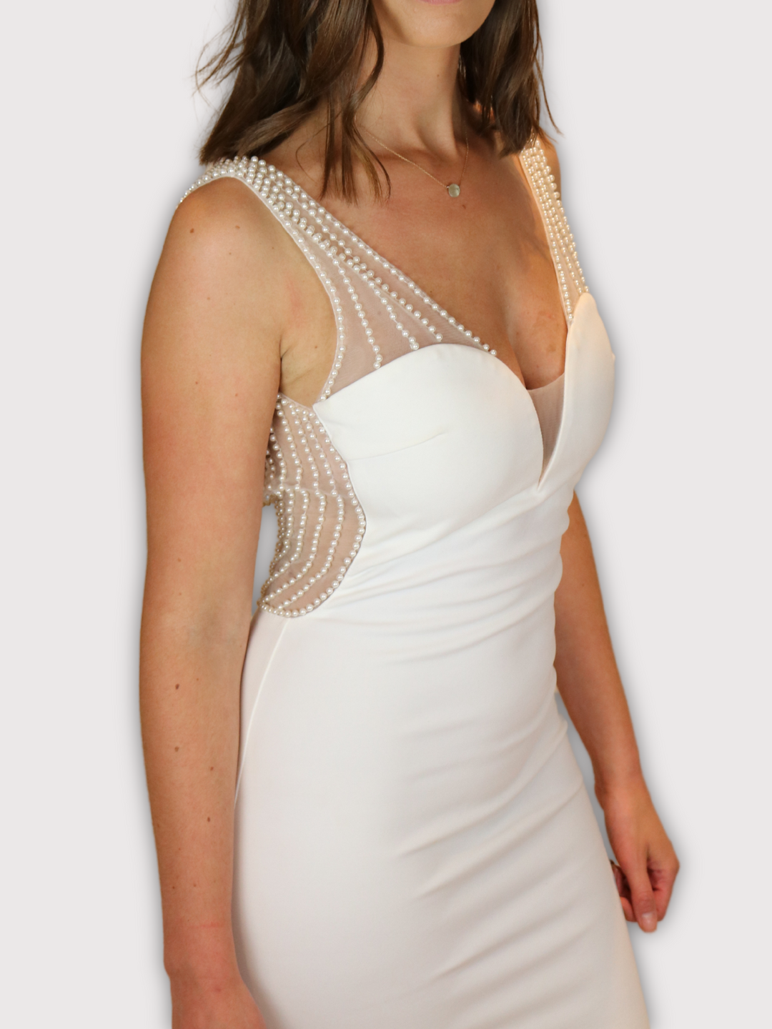 4ever Stunning Premium Deluxe Range Low Back Pearl Dress. Model looks straight into the camera. Front of the dress has sweat heart detailing and pearl detailed straps.