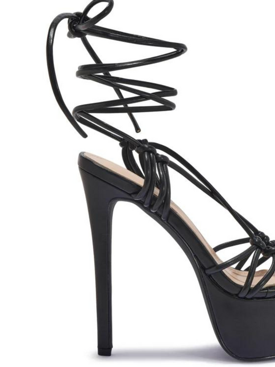 Black shoes with a thick platform base and stiletto heel. The shoe has a strappy thigh lace up design. The picture shoes the high stiletto heel and the lace up design.