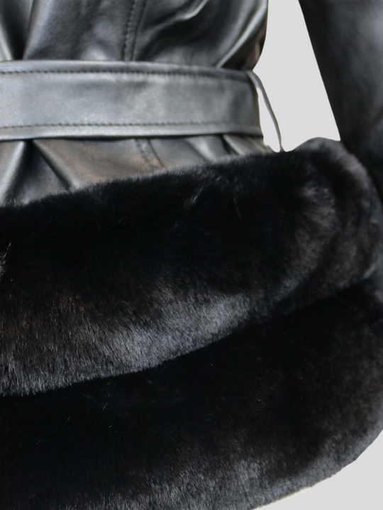 Close up shot. Ghost manequin wears a biker faux leather jacket with faux fur trim. The jacket has leather panelled detailing at the sleeves and exposed asymmetric chunky zip fastening. The faux leather jacket has a removable faux  belted waist.  Ghost manequin stands with their back to the camera, the  bottom part of the back of the jacket can be seen, including the faux fur trim and belted jacket.