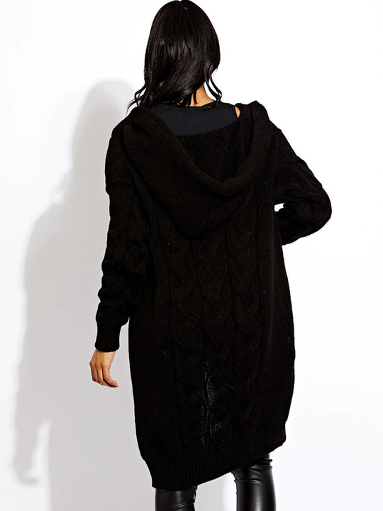 Female model stands in front of a plain background. The female model wears a long open cable knit Cardin in black. The cable knit cardigan has long sleeves. The model has light brown skin and long black hair,  she stands with her back to the camera, the back of the cardigan can be seen, including the cardigan's hood. 