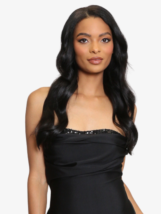 Female model stands in front of a plain background, she wears a black midi dress that has a ruched cup design and bandeau black sequin front insert. The midi dress also has a side split. The model has light brown skin and long black hair, the sequin bandeau front can be seen. 