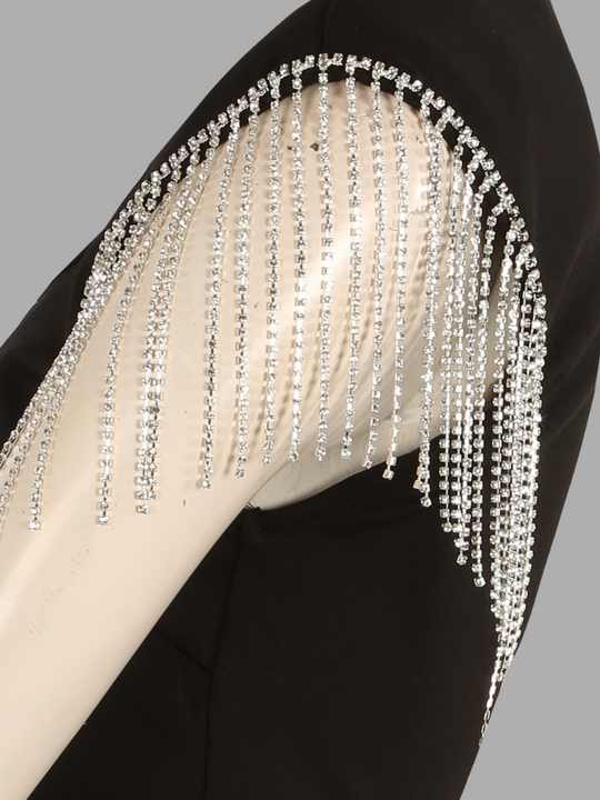 Close up of ghost manequins shoulder. The ghost manequin wears luxe black mini dress with diamante tasseled sleeves. The close up of the photograph shows the diamante tassels. 