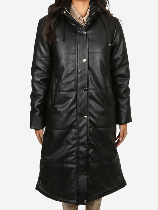 Mid length shot. Model stands in front of a plain background, she wears a longline black faux leather quilted coat, with zip front and front button fastening.  The model has tanned skin and long dark brown hair, she faces the camera, placing both hands by her side, the front button fastening can be seen. 