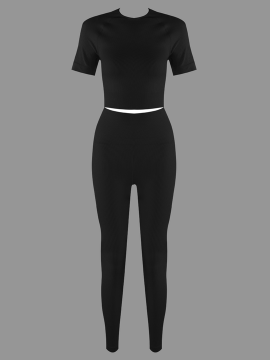 Full length ghost manequin shot. Ghost manequin wears a black ribbed crop top with short sleeves and matching ribbed leggings. The ghost manequin faces forward, the front of the co-ordinated set can be seen. 