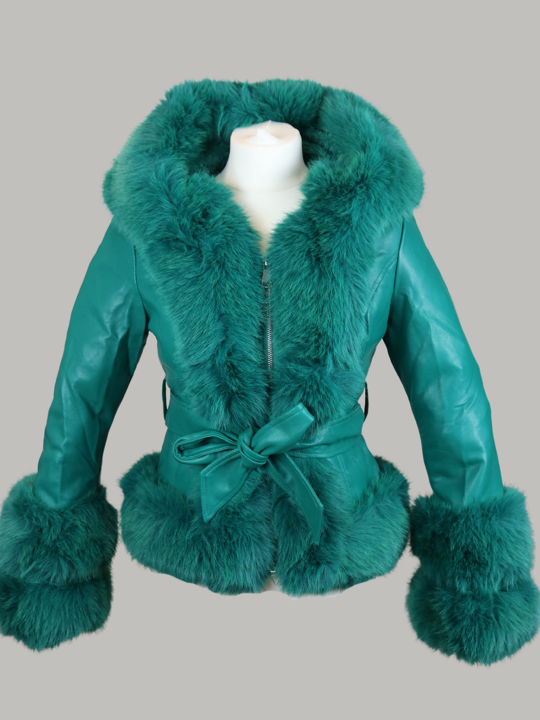 Ghost manequin wears a green faux leather jacket with green faux fur trim. The  green jacket has a faux fur hooded trim and large faux cuffs at the sleeves and a faux leather belt. 