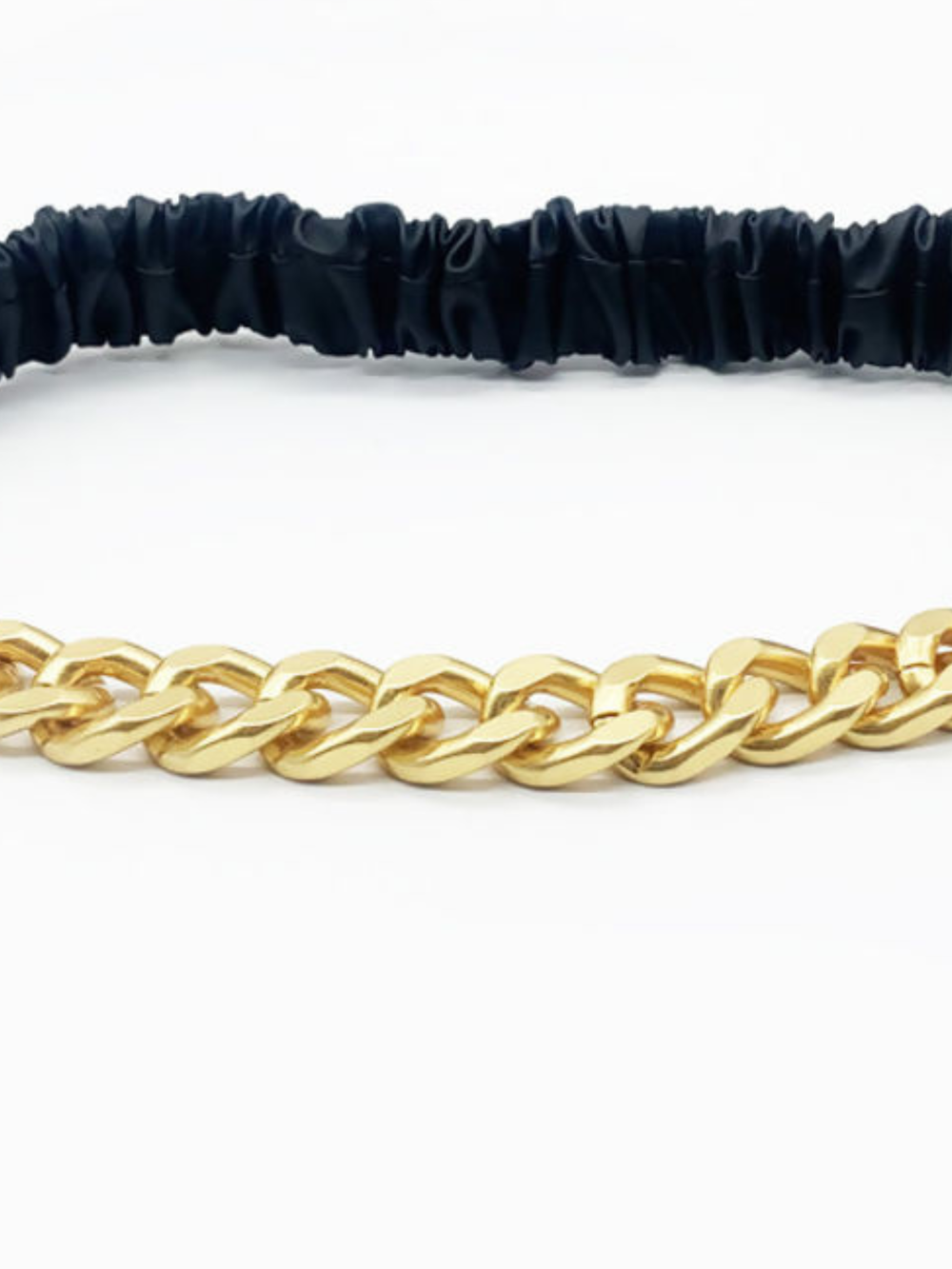 Close up. Gold chain belt with black elasticated adjustable belt, a close up of the gold chain can be seen. 