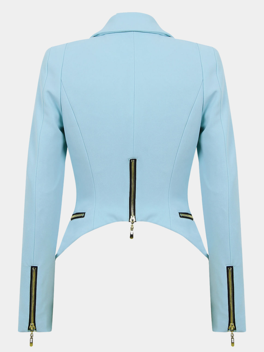 Ghost mannequin stands in front of a plain background. The ghost mannequin wears  a light blue blazer with a single front button fasten, long sleeves and  side zip pockets. The ghost mannequin  faces with their back to the camera, the back of the blazer can be seen, including the curved cropped back of the blazer. 