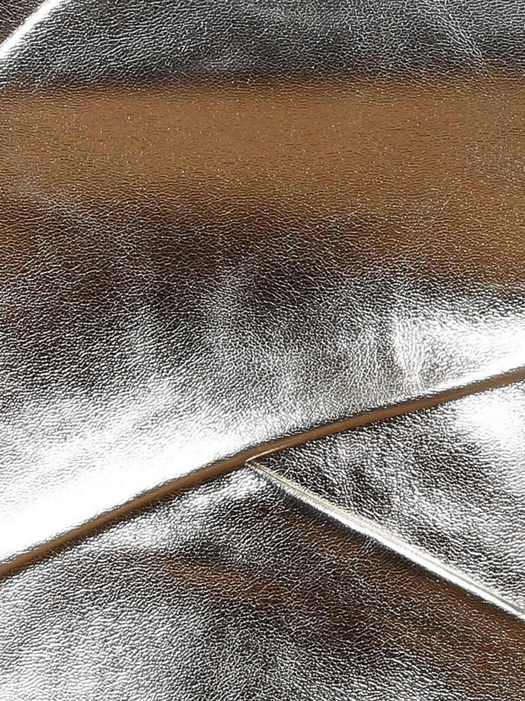 Close up of gold metallic top, including the cross over strap and shiny gold metallic coverings.