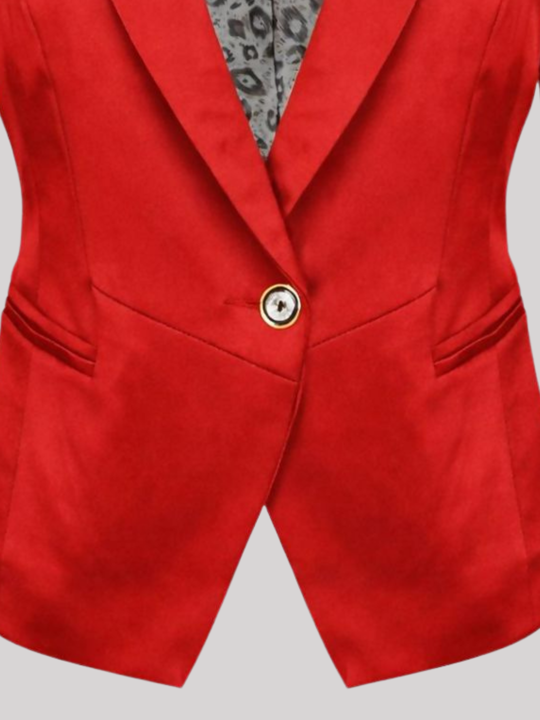 Close up. Ghost mannequin stands in front of a plain background. The ghost mannequin wears a red satin blazer, with single button fastening, with long sleeves, v neckline, front faux side pockets and red  satin lapel. The  close up shows a single button fastening.