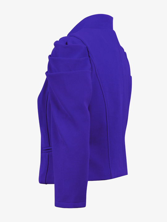Ghost mannequin stands in front of a plain background, the ghost mannequin wears a royal blue cropped blazer, with long sleeves and puffed sleeves. The blazer has a front  hook clasp fastening  and faux front side pockets. The ghost mannequin stands to the side, the side of the puffed sleeves can be seen.